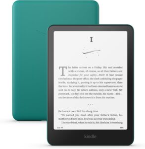 Sleek Kindle Paperwhite 2024 model in jade color, featuring a 7-inch glare-free display with a minimalist, lightweight design, lying next to a cup of coffee and an open book.