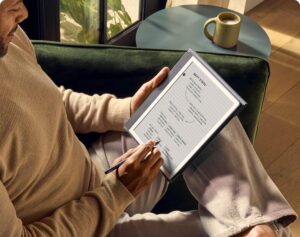 Amazon Kindle Paperwhite Signature Edition lying on a wooden table, displaying an open eBook on a crisp 6.8-inch glare-free screen with warm lighting."